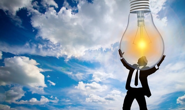 Clean energy access illustrated by man holding light bulb in the sky
