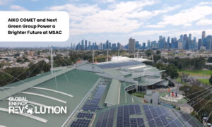 Rooftop solar panels on a modern building with a city skyline in the distance and a white rounded text balloon reading 'AIKO COMET and Next Green Group Power a Brighter Future at MSAC'; logo 'GLOBAL ENERGY REVOLUTION' in the corner. Rooftop solar panels on a modern building with a city skyline in the distance and a white rounded text balloon reading 'AIKO COMET and Next Green Group Power a Brighter Future at MSAC'; logo 'GLOBAL ENERGY REVOLUTION' in the corner.