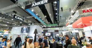 Crowded tech trade show floor with large booths and hanging brand signs like ANKER and CATL above the crowd. Crowded tech trade show floor with large booths and hanging brand signs like ANKER and CATL above the crowd.