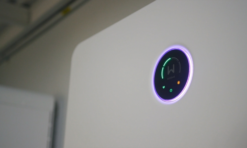 Round smart-device control panel with a glowing purple ring mounted on a white surface, showing status icons. Round smart-device control panel with a glowing purple ring mounted on a white surface, showing status icons.